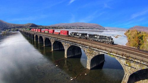 Arch bridge over river against sky