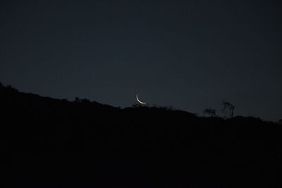 Low angle view of silhouette moon against sky at night