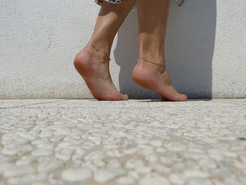 Low section of woman standing on footpath