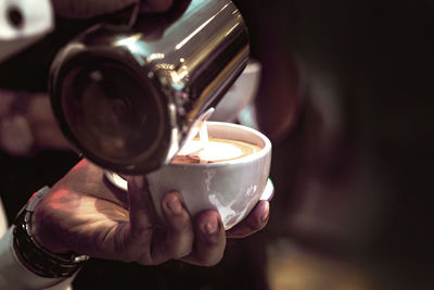 Close-up of hand holding coffee cup