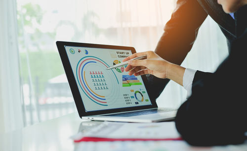 Midsection of businessman using laptop at office