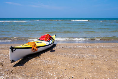 Boat moored on beach against sky