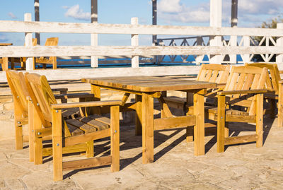 Empty chairs and table on beach
