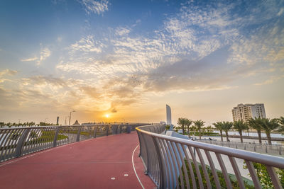 Bridge over road against sky during sunset
