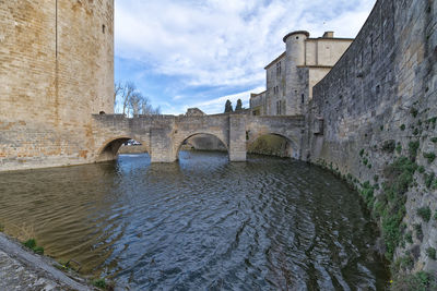 Arch bridge over river against sky