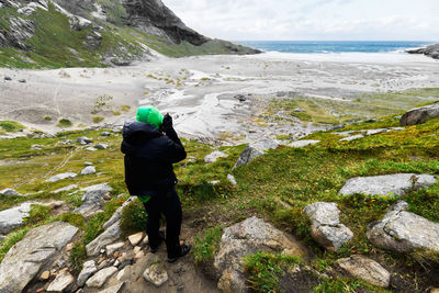 Rear view of person standing on rock