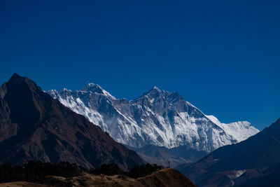 Scenic view of snowcapped mountains against clear blue sky