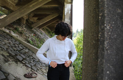 Full length of boy standing against stone wall