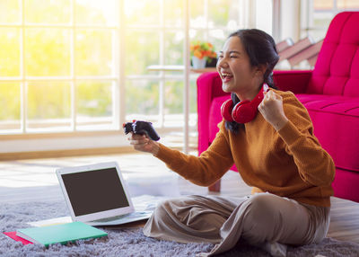 Young woman using mobile phone at home