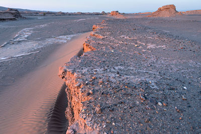 Rock formation on beach against sky