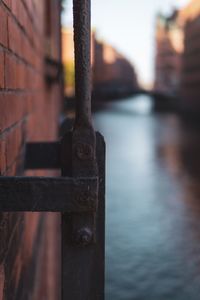 Close-up of rusty metal railing by river