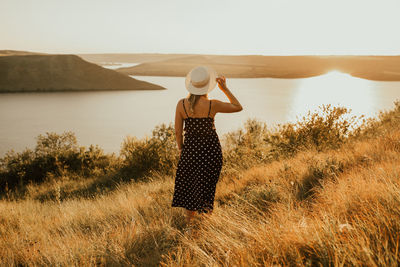 Rear view of woman standing on grassy field