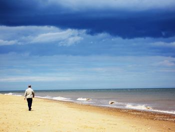 Rear view of man walking on beach