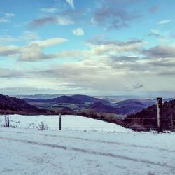 Scenic view of mountains against cloudy sky