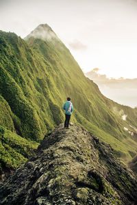 Rear view of man looking at mountain against sky