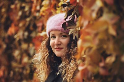 Close-up of young woman with autumn leaves