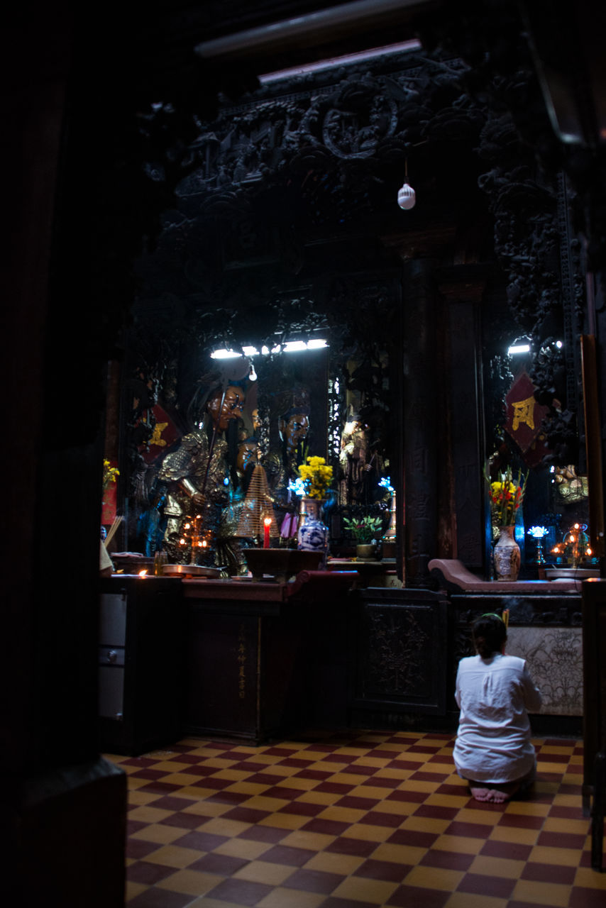 REAR VIEW OF A STATUE AGAINST ILLUMINATED TEMPLE