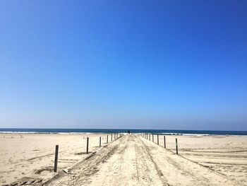 Scenic view of beach against clear blue sky