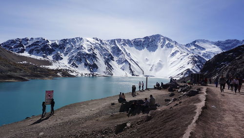 People on snowcapped mountain against sky