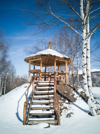 Built structure on snow covered land against sky