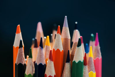 Close-up of colored pencils against black background