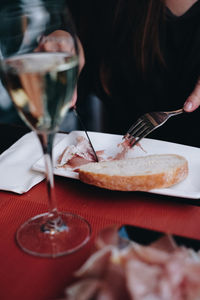 Midsection of woman holding drink served on table at restaurant