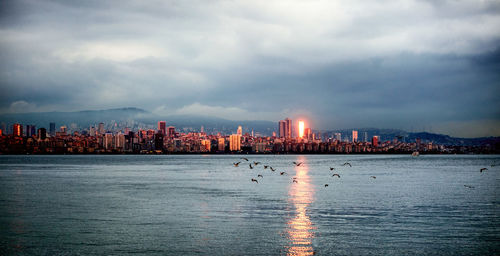 View of city by sea against sky