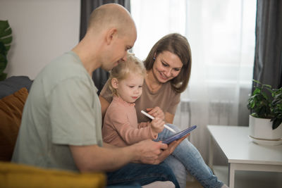 Mother and daughter using digital tablet at home