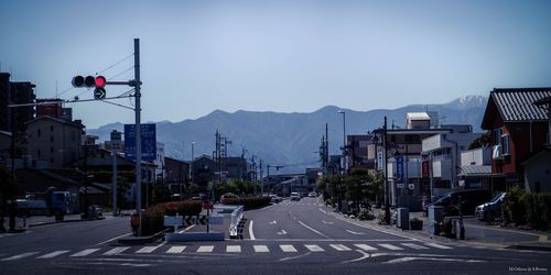 Road amidst buildings in city against sky