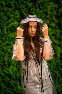 Young beautiful woman in hooded raincoat on rainy day
