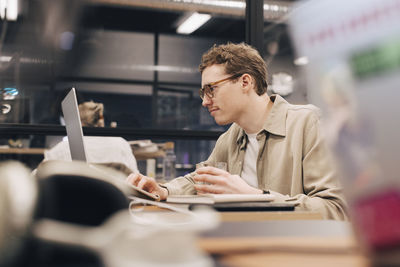 Dedicated businessman using laptop at desk in office