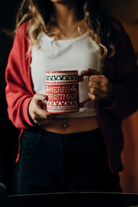 Midsection of woman holding coffee cup