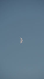 Low angle view of moon against clear blue sky