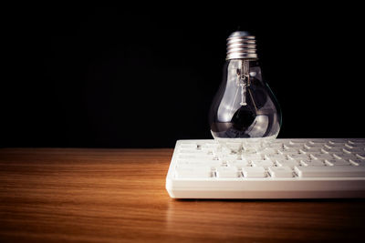 Telephone booth on table against black background