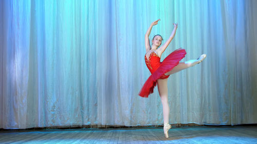 Ballet rehearsal, on the stage of the old theater hall. young ballerina in red ballet tutu 