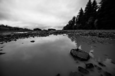 View of calm lake against cloudy sky