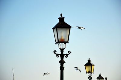 Low angle view of street light against blue sky