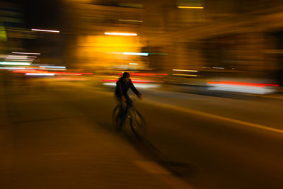 Blurred motion of people walking on road at night