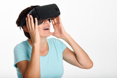 Mature woman using virtual reality against white background