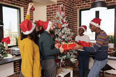 Rear view of woman holding christmas tree