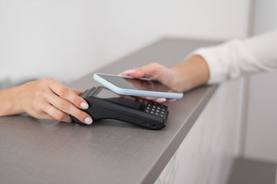 A woman pays using a non -contact payment of the nfc used by a smartphone