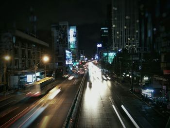 Light trails on road along buildings at night