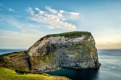 Rock formations by sea against sky