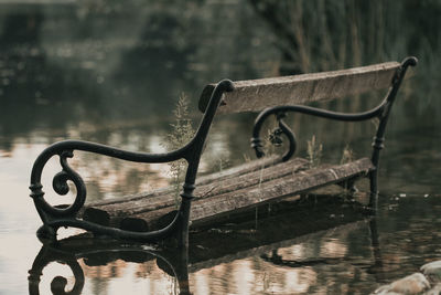 Close-up of bench against lake