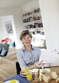 Portrait of mature woman eating breakfast at table