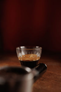 Holder of coffee machine on wooden table with espresso glass