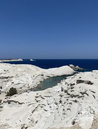 Scenic view of beach against clear blue sky