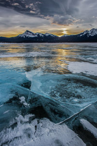 Scenic view of frozen lake against sky during sunset