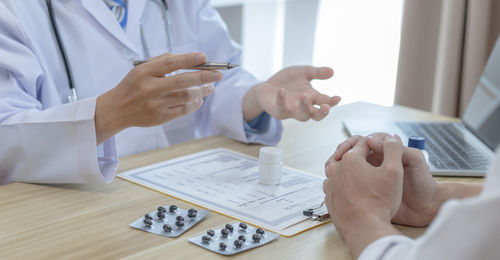 Midsection of doctor counseling patient at clinic