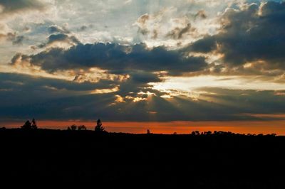 Silhouette of landscape against cloudy sky